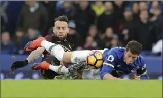  ?? PETER BYRNE, THE ASSOCIATED PRESS ?? Manchester City’s Nicolas Otamendi, left, challenges Everton’s Ross Barkley for the ball during Everton’s 4-0 win Sunday in Liverpool.