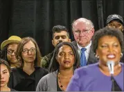  ??  ?? DuBose Porter (second from right), chairman of the Georgia Democratic Party, and Lauren Groh-Wargo (third from left), Stacey Abrams’ campaign manager, listen as the candidate explains why she is ending her campaign.