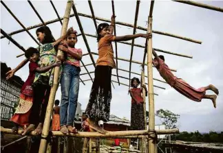  ?? Altaf Qadri/Associated Press ?? Crianças rohingya brincam em uma área para refugiados em Bangladesh