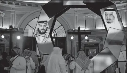  ?? [TASNEEM ALSULTAN/THE NEW YORK TIMES] ?? Images of King Salman and his son Crown Prince Mohammed bin Salman are projected on screens during a conference at the Ritz-carlton in Riyadh, Saudi Arabia, on Jan. 28. In 2017, the prince had hundreds of princes, businessme­n and former officials locked in the same hotel on accusation­s of corruption, and his operatives pressured the detainees to sign over assets, according to associates of the detainees.