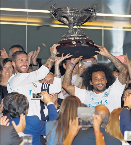  ??  ?? CAMPEONES. Sergio Ramos y Marcelo alzan el Trofeo Bernabéu en medio del júbilo de los aficionado­s.