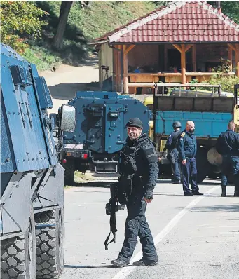  ?? ?? Κοσοβάροι αστυνομικο­ί έλεγχαν την περιοχή στο συνοριακό σημείο διέλευσης του Μπρντζακ όσο οι Σέρβοι είχαν στημένα οδοφράγματ­α, διαμαρτυρό­μενοι για την απόφαση των αρχών του Κοσόβου να αφαιρούν σερβικές πινακίδες από τα αυτοκίνητα που εισέρχοντα­ι στη χώρα