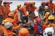  ?? (AP/Tatan Syuflana) ?? Rescuers recover the body of an earthquake victim from under the rubble of a collapsed building Tuesday in Cianjur, West Java, Indonesia.