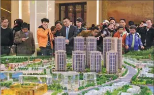  ?? XU FENGSHAN / FOR CHINA DAILY ?? Potential homebuyers inquire about Poly Group’s housing projects at a sales agency in Guiyang, Guizhou province.