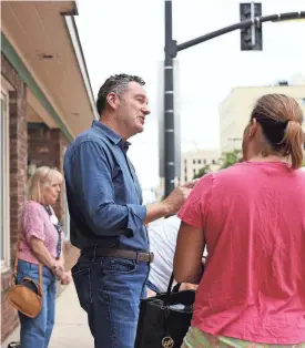  ?? SAMANTHA MADAR/USA TODAY NETWORK-WISCONSIN ?? Tim Michels, a Republican candidate for Wisconsin governor, speaks with people outside his campaign headquarte­rs on East Walnut Street in Green Bay on Tuesday.