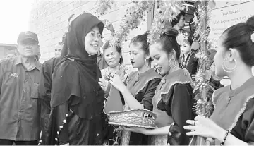  ??  ?? Young Melanau girls greet Fatimah upon her arrival at the event.