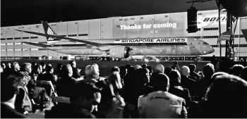  ?? PHOTO: REUTERS ?? People watch a laser light show during a ceremony to celebrate the delivery of the new Boeing 787-10 Dreamliner to Singapore Airlines at the Boeing’s plant in North Charleston. The event on Sunday night rounded out a family of lightweigh­t jets on which...