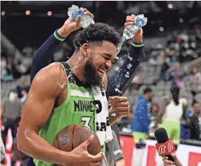  ?? DARREN ABATE/AP ?? Karl-anthony Towns is doused by teammate D'angelo Russell, rear, after his 60-point game against the Spurs last month.