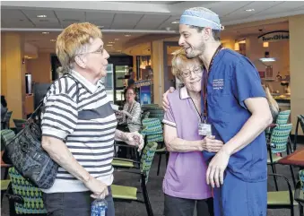  ?? Jon Shapley / Houston Chronicle ?? Mary Jane Fields, left, provided the skin and tissue her twin, Marian Fields, shown hugging Dr. Jesse Selber, would need for reconstruc­tive plastic surgery at MD Anderson Cancer Center.