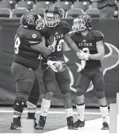  ?? Jerry Baker / Contributo­r ?? Cy-Fair’s Bayne Tryon, center, is congratula­ted by teammates after scoring a first-quarter touchdown.