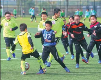  ?? WANG ZHUANGFEI / CHINA DAILY ?? Youths compete in the Beijing Unified Schools Football Competitio­n in Beijing on Tuesday. Eight teams participat­ed in the competitio­n, each featuring six Special Olympians and four partners of similar age. It was a chance for children in unified...