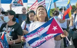  ?? MATIAS J. OCNER/MIAMI HERALD ?? Edith Pacheco holds a Cuban flag during a rally outside of the Versailles Restaurant in Miami’s Little Havana neighborho­od on Monday. The rally was held in solidarity with protests that were supposed to happen throughout Cuba.