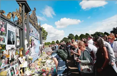  ?? KIRSTY WIGGLESWOR­TH/AP PHOTO ?? People crowd around the gates of Kensington Palace in London to pay tribute to the late Diana, Princess of Wales, Thursday. Tributes at the gates mark the 20th anniversar­y of Diana’s death, in a car crash in Paris on Aug. 31, 1997.