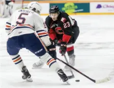  ?? CITIZEN PHOTO BY JAMES DOYLE ?? Prince George Cougars forward Aaron Boyd fights for the loose puck against Kamloops Blazers defender Montana Onyebuchi on Saturday night at CN Centre.