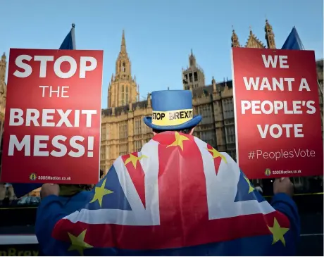  ?? Reuters ?? An anti-Brexit demonstrat­or holds placards opposite the Houses of Parliament in London on Tuesday. —