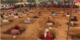  ??  ?? Farmers sitting in pits to protest against acquisitio­n of their land in Rajasthan.