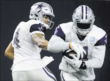  ?? LM OTERO/THE ASSOCIATED PRESS ?? Dallas Cowboys running back Ezekiel Elliott, right, takes a handoff from quarterbac­k Dak Prescott during a Jan. 7 practice at team headquarte­rs in Frisco, Texas. Prescott and Elliott had oustanding regular seasons for the NFC top-seeded Cowboys, who...