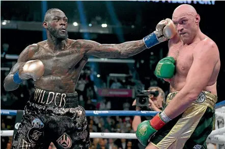  ?? GETTY IMAGES ?? Deontay Wilder punches Tyson Fury in the ninth round of their drawn WBC heavyweigh­t bout.