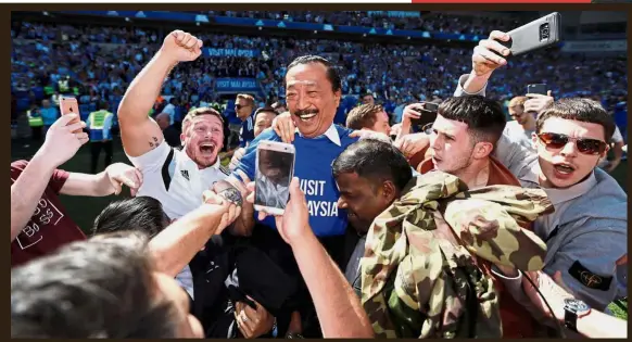  ?? — Reuters ?? On cloud nine: Cardiff owner Tan Sri Vincent Tan (centre) celebratin­g with fans at the Cardiff City Stadium after the club won promotion to the Premier League yesterday.