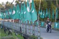  ?? — Reuters ?? A motorcycli­st passes PAS flags in Kota Bharu, Kelantan.