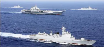  ??  ?? China’s aircraft carrier Liaoning (centre) takes part in a military drill of Chinese People’s Liberation Army (PLA) Navy in the western Pacific Ocean. — Reuters photo