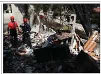  ?? AP/THANASSIS STAVRAKIS ?? Members of a rescue team search a burned house Wednesday in Mati, Greece, part of an area around Athens where wildfires spread rapidly this week, fanned by gale-force winds.