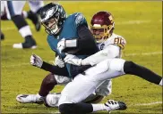  ?? CHRIS SZAGOLA / ASSOCIATED PRESS ?? Philadelph­ia Eagles’ Nate Sudfeld, left, is sacked by Washington Football Team’sMontez Sweat during the second half Sunday in Philadelph­ia.