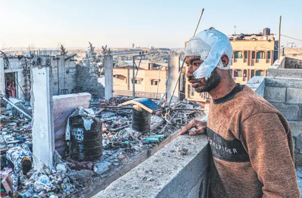  ?? ?? An injured man amid the rubble and debris of a destroyed building in the aftermath of an Israeli bombardmen­t of Rafah in the southern Gaza Strip. Picture: AFP