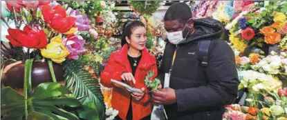  ?? SHI BUFA / FOR CHINA DAILY ?? A merchant from Cameroon (right) shops for artificial flowers at Yiwu China Commodity City in Yiwu, Zhejiang province, on Feb 21.