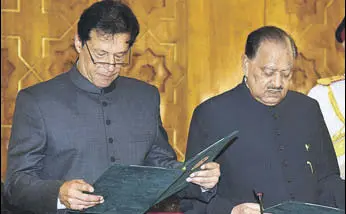 ?? AP ?? Pakistani President Mamnoon Hussain administer­s oath of office to Imran Khan on Saturday.
