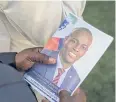  ?? REUTERS ?? A person holds a photo of late president Jovenel Moise.