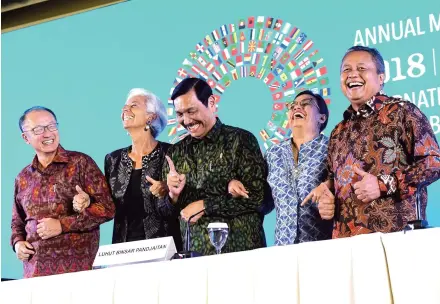 ??  ?? World Bank President Jim Yong Kim, IMF chief Christine Lagarde, Indonesian ministers and Central Bank governor pose for a photo at the close of the meetings.