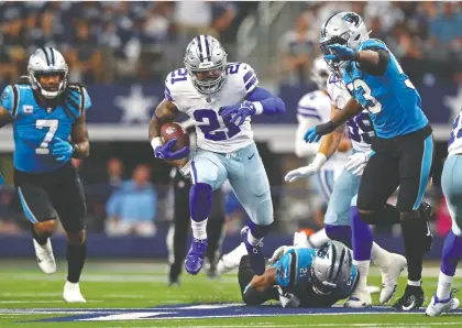  ?? MARK J. REBILAS/USA TODAY SPORTS ?? Dallas running back Ezekiel Elliott runs the ball against the Carolina Panthers during Sunday's NFL game at AT&T Stadium in Arlington, Texas. Elliott finished with 143 yards on 20 carries in the Cowboys' 36-28 victory.