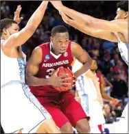  ?? NWA Democrat-Gazette/J.T. WAMPLER ?? North Carolina defenders Kennedy Meeks (left) and Isaiah Hicks (right) try to box in Arkansas forward Moses Kingsley, who finished with nine points and five rebounds in his final college game.
