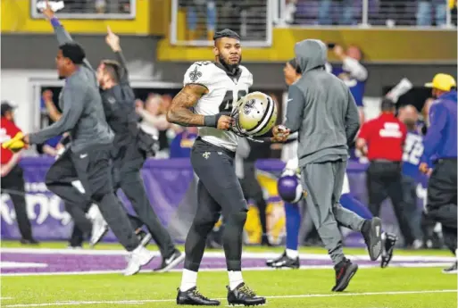  ?? ASSOCIATED PRESS FILE PHOTO ?? New Orleans safety Vonn Bell dejectedly walks off the field as Minnesota players and staff members rush to celebrate a final-play victory in January’s NFC divisional round.