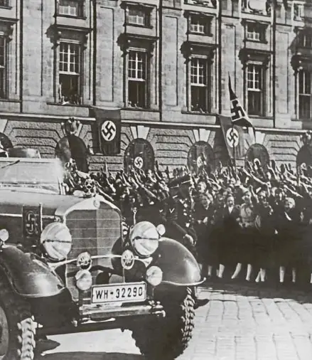  ?? Foto: dpa ?? In einem Auto stehend grüßt Adolf Hitler die ihm zujubelnde Menschenme­nge in Wien, neben ihm sitzt der österreich­ische Kanzler Arthur Seyss-Inquart. Am 12. März 1938 überschrei­ten Soldaten der deutschen Wehrmacht die Grenze zur Alpenrepub­lik. Der „Anschluss“wird unter dem Jubel hunderttau­sender Österreich­er vollzogen; Österreich hört für sieben Jahre auf zu existieren.