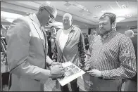  ?? Arkansas Democrat-Gazette/THOMAS METTHE ?? Former Arkansas Razorbacks basketball player Darrell Walker (left) signs autographs for fans after the Southwest Conference Hall of Fame ceremony at the Little Rock Touchdown Club luncheon on Monday. Walker was one of 13 former Razorbacks to go into...