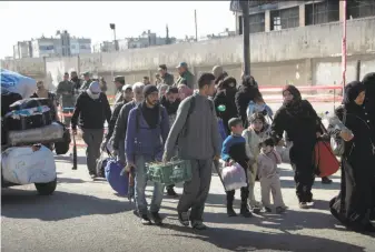  ?? SANA ?? As part of a deal with the Syrian government, opposition fighters are allowed to head to a bus with their families as they leave the last rebel-held neighborho­od of the city of al-Waer.