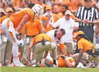  ?? STAFF PHOTO BY ROBIN RUDD ?? Tennessee’s Ethan Wolf, left, and coach Butch Jones check on the injured Eli Wolf during Saturday’s game against Indiana State. The Wolfs are brothers.