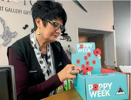  ?? HANNAH MCLEOD/FAIRFAX NZ 634055534 ?? Southland Museum and Art Gallery retail assistant Lowanna Clearwater checks out the poppies on sale for the Poppy Appeal.