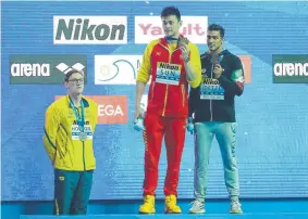 ?? Picture: GETTY IMAGES ?? OBJECTING: China’s Sun Yang holds up his gold medal as silver medallist Mack Horton stands away from the podium.