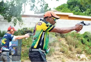  ?? LIONEL ROOKWOOD/PHOTOGRAPH­ER ?? Jamaica’s Lesgar ‘Speedy’ Murdock (right) in action during the Open Division shoot-off against Argentina’s Daniel Minaglia during yesterday’s final day of the Pan American Handgun Championsh­ips at the Jamaica Rifle Associatio­n’s Mountain View Range.