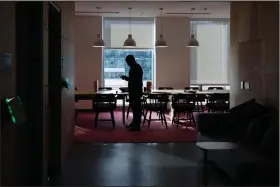  ?? (AP file photo) ?? A man checks his phone inside Facebook’s facility in Cambridge, Mass. In a move resisted by Facebook, Apple has released a software update that will require apps to receive users’ consent to track online activities.