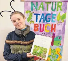  ?? FOTO: BUNDJUGEND ?? Maskottche­n „Manfred Mistkäfer“mit dem Naturtageb­uch von Greta Hege und Mirja Schättiger aus Isny, die einen ersten Preis gewonnen haben.