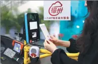  ?? HU MEIDONG / CHINA DAILY ?? A woman in Fuzhou scans her e-Fuzhou app to board a bus. The app helps locals a lot in their daily lives.