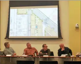  ?? DAN SOKIL — DIGITAL FIRST MEDIA ?? Lansdale Planning Commission members view the latest version of plans for a complex of apartment buildings to be built atop the Madison Parking Lot in Lansdale, with detail on where a trash enclosure will be located near a pedestrian bridge running...