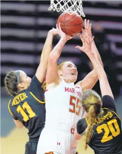  ?? JULIO CORTEZ/ASSOCIATED PRESSS ?? Maryland forward Chloe Bibby, center, goes up for a shot against Iowa guard Megan Meyer, left, and guard Kate Martin on Tuesday.