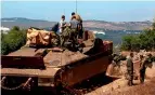  ?? AFP ?? BORDER SECURITY: Israeli soldiers stand atop a military vehicle in northern Israel along the border with Lebanon on Thursday.—