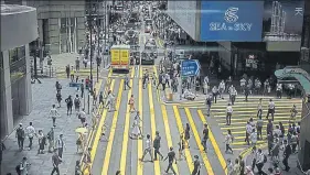  ?? BLOOMBERG ?? ■
Pedestrian­s cross Queen's Road in the Central district in Hong Kong on Thursday.