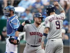  ?? AP Photo/Orlin Wagner ?? ■ Houston Astros' Max Stassi (12) celebrates with teammate Marwin Gonzalez (9) after hitting a three-run home run during the sixth inning Saturday against the Kansas City Royals at Kauffman Stadium in Kansas City, Mo. Kansas City Royals catcher Drew Butera, left, waits for the next batter.